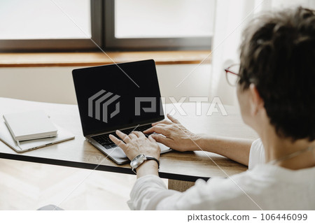 Back view of senior business woman using laptop. 106446099