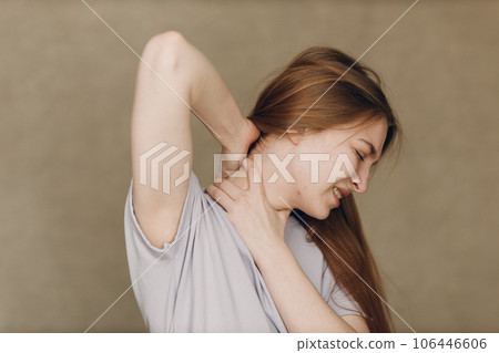 Young woman with upper neck pain ache against brown background Young woman with upper neck pain ache against brown background 106446606