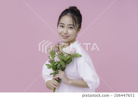 一位年輕女子的肖像，有一束粉紅色背景 106447651