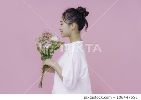一位年輕女子的肖像，有一束粉紅色背景 106447653