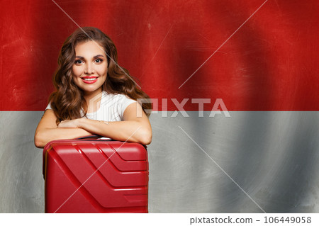 Smiling woman with red suitcase on Monaco flag background. Travel, work 106449058