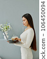 Side view of young Asian woman using laptop. 106450094