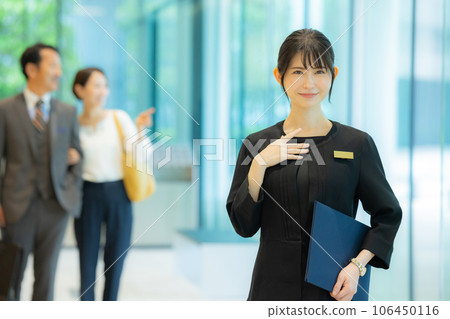 A woman at the reception guiding middle couples A woman at the reception guiding middle couples 106450116