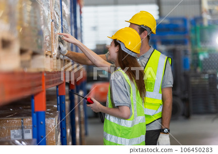 Male and Female professional worker wearing safety uniform inspect goods on shelves in warehouse. Male and Female professional worker wearing safety uniform inspect goods on shelves in warehouse. 106450283