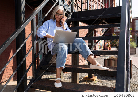 pretty fashionable middle-aged woman with gray hair dressed in a summer style conducts her business pretty fashionable middle-aged woman with gray hair dressed in a summer style conducts her business 106450805