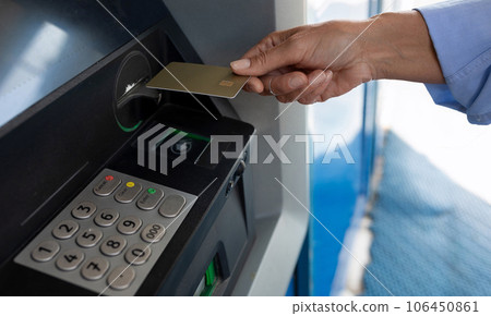 a woman held a plastic card to an ATM 106450861