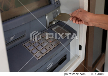 female hand pulls a credit card to the ATM 106450888