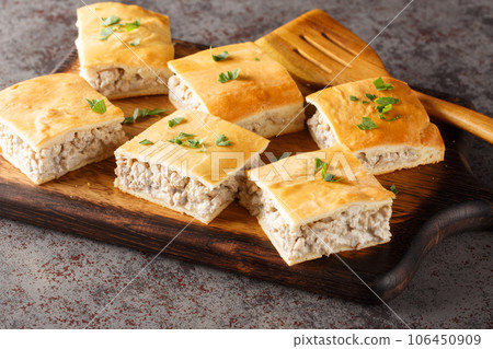 Italian sausage gratin with cream cheese with crescent crust close-up on a board. horizontal Italian sausage gratin with cream cheese with crescent crust close-up on a board. horizontal 106450909