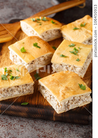 Homemade casserole of minced Italian sausages with cream cheese close-up on a wooden board. Vertical Homemade casserole of minced Italian sausages with cream cheese close-up on a wooden board. Vertical 106450913