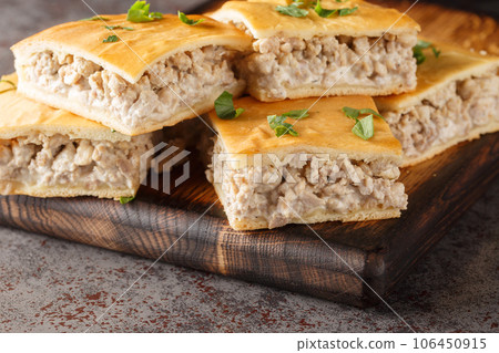 Savory pie for breakfast of italian sausages with cream cheese close-up on a wooden board. horizontal 106450915