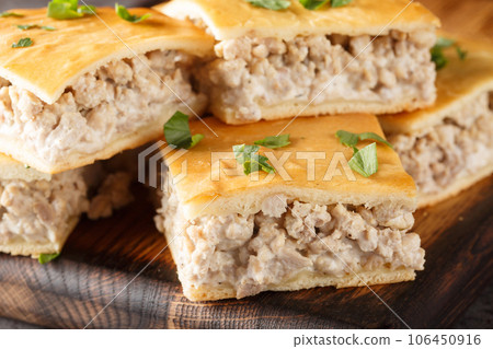 Crescent dough pie of minced pork with cream cheese close-up on a wooden board. horizontal Crescent dough pie of minced pork with cream cheese close-up on a wooden board. horizontal 106450916