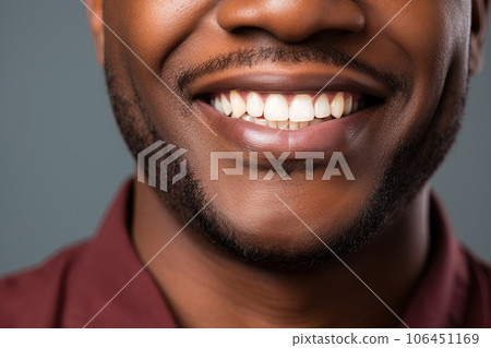 Happily smiling African American young man with perfectly white even teeth. Smiling mouth close up. 106451169