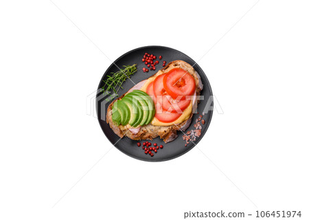 Delicious nutritious grilled toast with ham, cheese, tomatoes and avocado 106451974