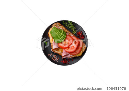 Delicious nutritious grilled toast with ham, cheese, tomatoes and avocado 106451976
