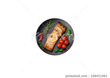 Slice of delicious baked fish with salt, spices and herbs on a ceramic plate Slice of delicious baked fish with salt, spices and herbs on a ceramic plate 106451981