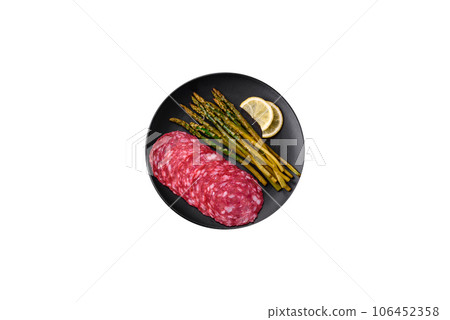 Delicious nutritious breakfast consisting of sliced sausage, asparagus, salt, spices and herbs 106452358