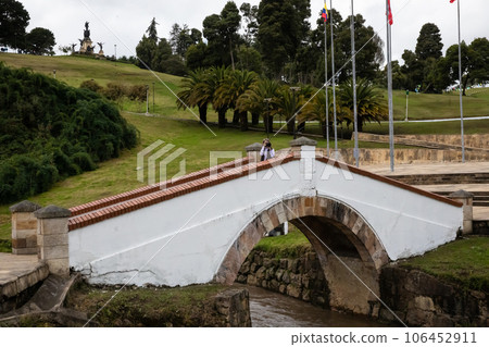 Female tourist taking pictures at the famous historic Bridge of Boyaca in Colombia. The Colombian independence Battle of Boyaca took place here on August 7, 1819. Female tourist taking pictures at the famous historic Bridge of Boyaca in Colombia. The Colombian independence Battle of Boyaca took place here on August 7, 1819. 106452911