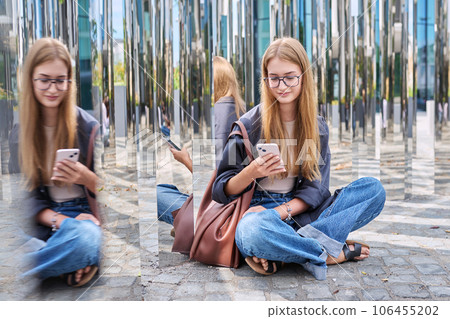 Young smiling female using smartphone, urban mirror background 106455202