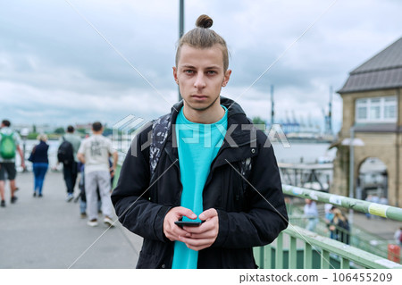 Portrait of handsome guy 19, 20 years old, modern city background 106455209