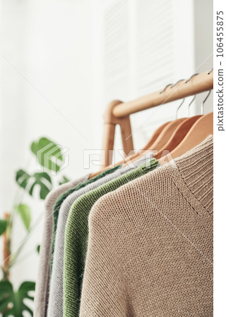 Multicolored handknitted sweaters on hangers 106455875