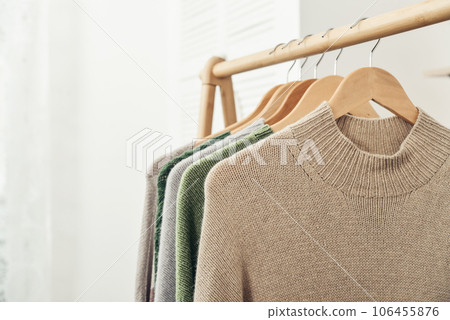 Multicolored handknitted sweaters on hangers 106455876