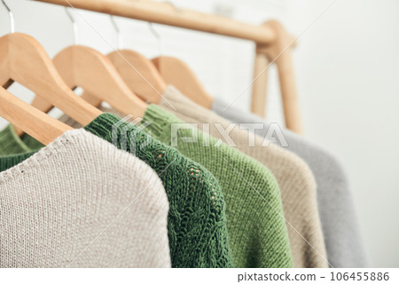 Multicolored handknitted sweaters on hangers Multicolored handknitted sweaters on hangers 106455886
