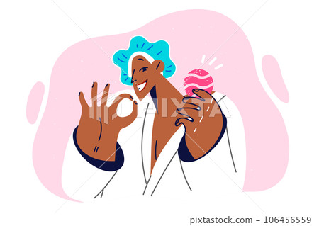 Woman with bath bomb in hands shows gesture of OK and smiles, calling for use of aromatherapy 106456559