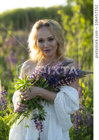 beautiful blond woman in white dress on lupin field summer background close up portrait beautiful blond woman in white dress on lupin field summer background close up portrait 106457352