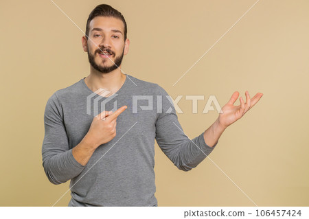 Lebanese man showing thumbs up and pointing empty blank place, advertising area for commercial text 106457424