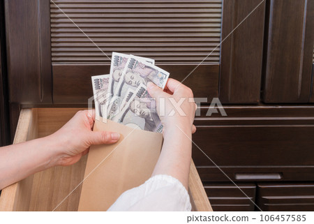 [一位家庭主婦將一張一萬日元的鈔票藏在抽屜裡的信封裡] 106457585