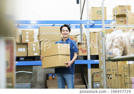 Young man working in a warehouse 106457729