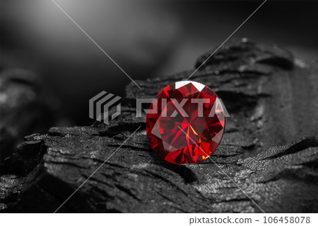 Red Ruby gemstone Round Cut on black coal background, close up shot 106458078