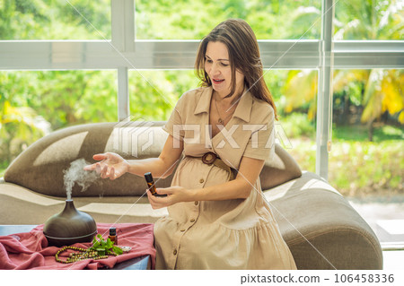 A serene moment captured as a pregnant woman after 40 embraces the soothing benefits of aroma oils and an aroma diffuser, enhancing her pregnancy journey with relaxation and tranquility 106458336