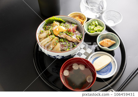 Bowl of rice topped with sashimi  106459431