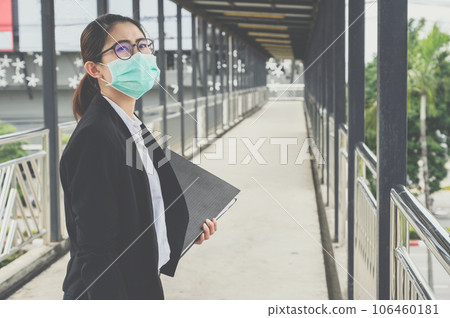 Young Asian businesswoman wearing mask for protect virus disease when going outside to work in covid-19 pandemic. Young Asian businesswoman wearing mask for protect virus disease when going outside to work in covid-19 pandemic. 106460181