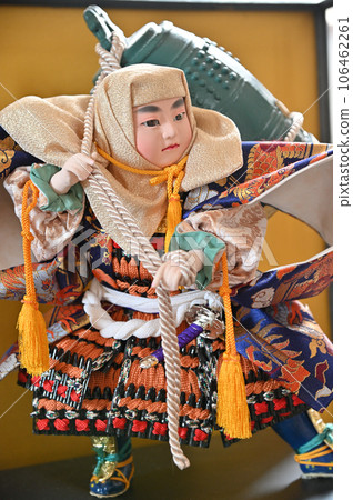 A boy carrying a heavy temple bell of May dolls A boy carrying a heavy temple bell of May dolls 106462261