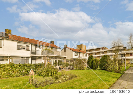 some houses in the day time with blue sky and white clouds above them, as seen from an outside view 106463640