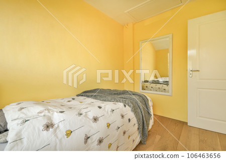 a bedroom with yellow walls and wood flooring in the fore - image is taken from another room to the right 106463656
