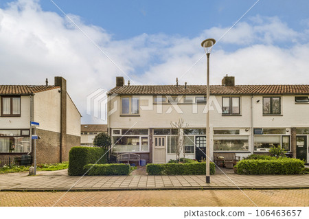 some houses in the middle of an urban area with blue sky and white clouds above them on a sunny day some houses in the middle of an urban area with blue sky and white clouds above them on a sunny day 106463657