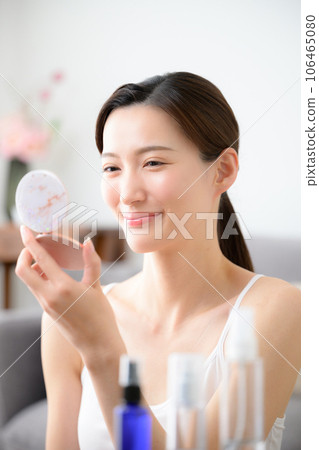 Photo of a beautiful woman finishing her makeup, vertical Photo of a beautiful woman finishing her makeup, vertical 106465080
