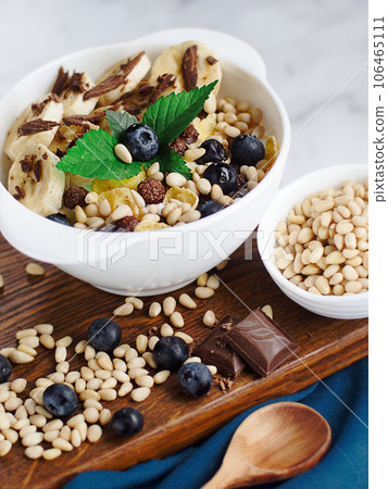 Useful breakfast. Fruit salad with banana, pine nuts, blueberries, chocolate and corn flakes Useful breakfast. Fruit salad with banana, pine nuts, blueberries, chocolate and corn flakes 106465111