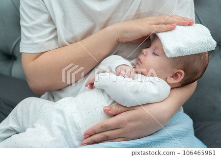 Wet towel comforts a feverish infant, Concept of mother's instinctive care response 106465961