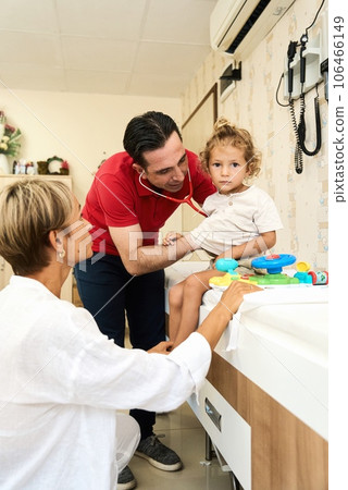Happy male doctor have fun cheer support boys patients at visit to clinic with mom. Children 106466149