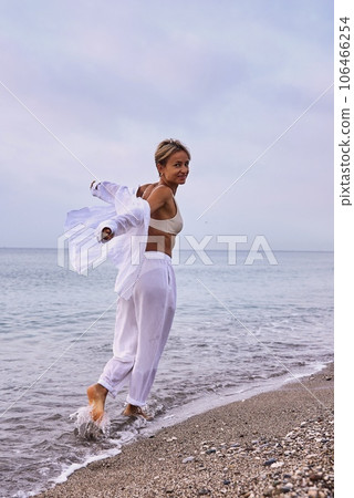 Fashionable woman wearing white linen suit, straw hat enjoy morning sea. Summer sunrise at sea Fashionable woman wearing white linen suit, straw hat enjoy morning sea. Summer sunrise at sea 106466254