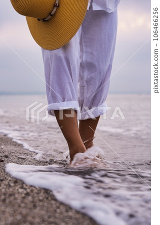 Fashionable woman wearing white linen suit, straw hat enjoy morning sea. Summer sunrise at sea Fashionable woman wearing white linen suit, straw hat enjoy morning sea. Summer sunrise at sea 106466256
