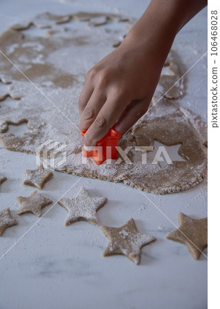 Hands of little 6 years old child with cookies in shape of star. cooking concept Hands of little 6 years old child with cookies in shape of star. cooking concept 106468028