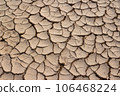 Sun-dried and cracked mud after puddle drying 106468224