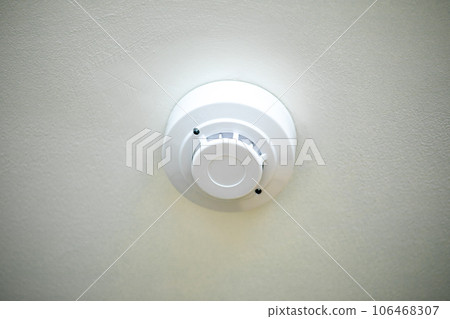 Fire alarm detector on the ceiling with white background. Close-up. 106468307