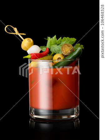 Glass of vodka and tomato juice bloody mary cocktail with spicy snack on cocktail stick on black. 106468328