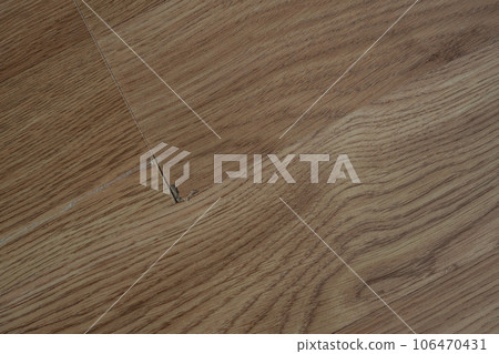 Laminate flooring with visible defects like chips, cracks, and unevenness. Laminate flooring with visible defects like chips, cracks, and unevenness. 106470431